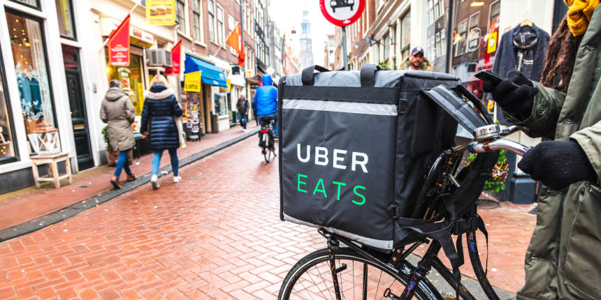 Livreur à vélo d’Uber Eats vérifiant son téléphone