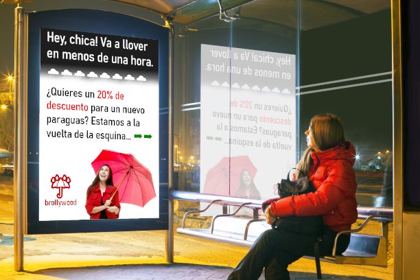Anuncio biométrico que promociona una tienda de paraguas a un pasajero que espera