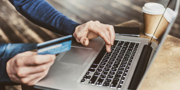 Internet shopper entering credit card information using laptop computer keyboard. Online shopping concept