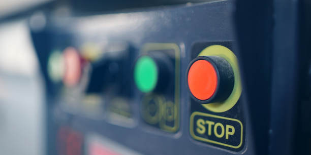 Botón grande y rojo con el mensaje PARAR en una máquina industrial