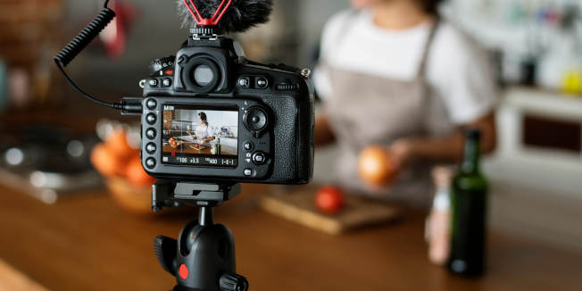 Female vlogger recording cooking related broadcast at home