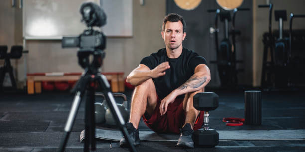 Un Vlogger de fitness grabando un video de sí mismo en el gimnasio