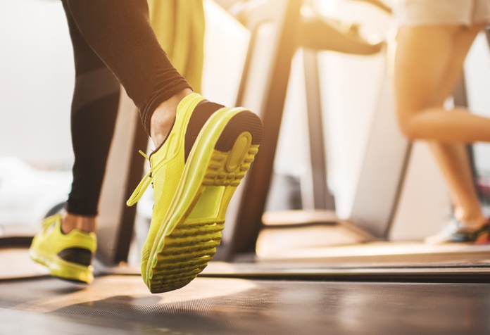 Woman in bright yellow sneakers running on a treadmill