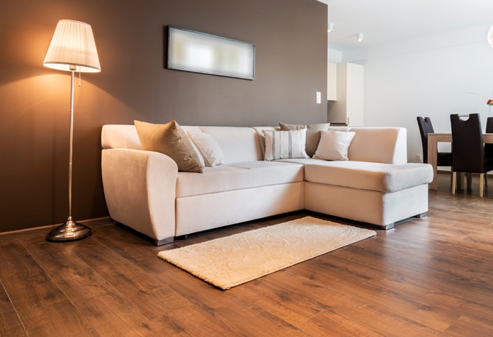 Una sala de estar moderna con sofá, sillas y pisos de madera.