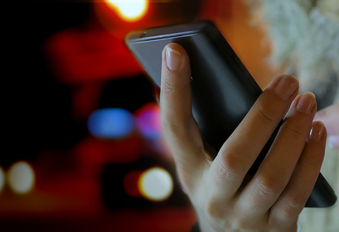 La mano de una mujer sosteniendo un móvil inteligente.