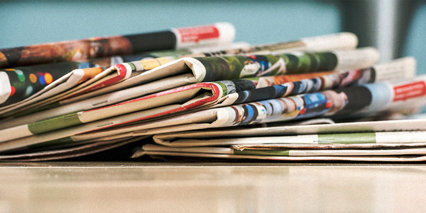Stack of newspapers on a table.