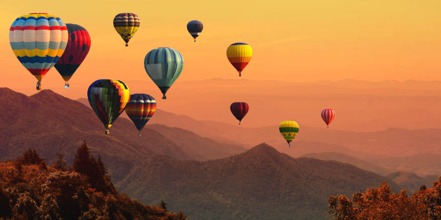 Hot air balloons above high mountains at sunset