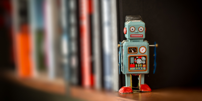 Retro tin toy robot standing on a wooden bookshelf