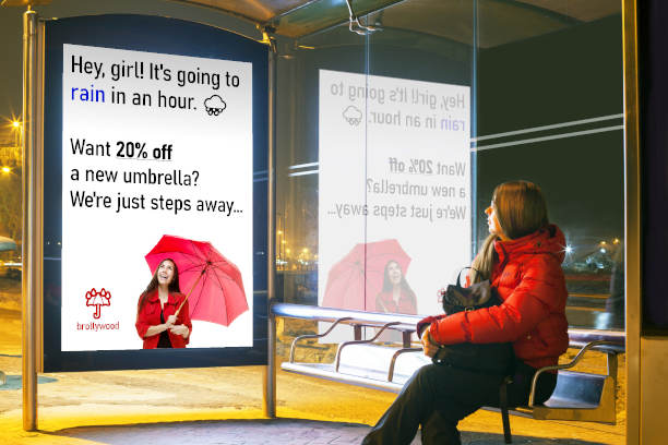 Biometrische Werbung an Bushaltestellen, die für einen wartenden Passagier ein Geschäft für Regenschirme bewirbt