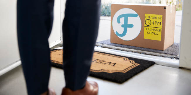 Close Up Of Man Opening Front Door To Fresh Food Home Delivery In Cardboard Box Outside Front Door
