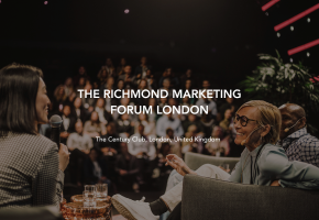 A woman speaks into a microphone while seated on stage with two other people in front of an audience. Text overlay reads: "The Richmond Marketing Forum London, The Century Club, London, United Kingdom."