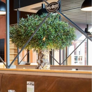Un olivier décoratif dans un restaurant avec un panneau "Del Arte".