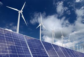 Granjas de energía eólica y paneles solares bajo un cielo parcialmente nublado.