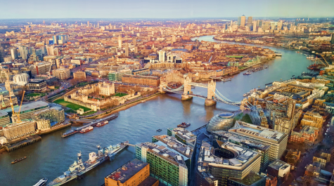 Aerial view of London with the River Thames, featuring Tower Bridge and surrounding buildings.