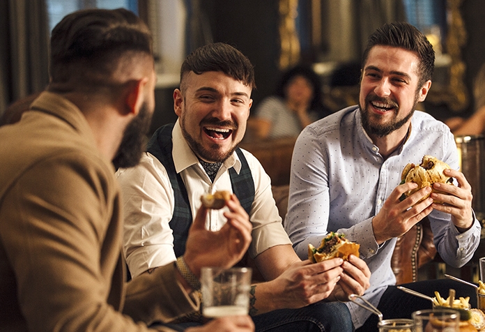 Three friends enjoying hamburgers together