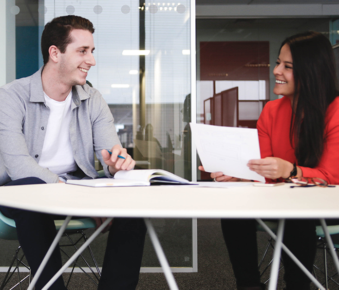 Two coworkers collaborating in a bright office