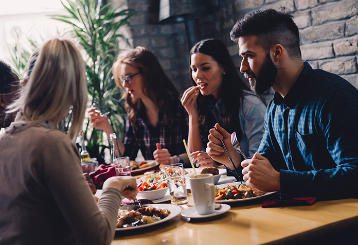 Young professionals discussing ideas over dinner in a restaurant