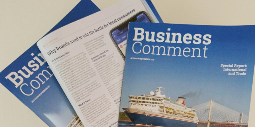 Stacked copies of Business Comment magazine