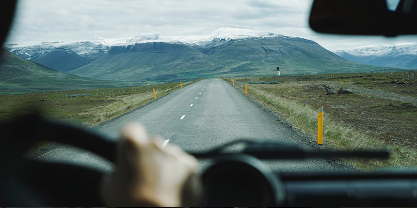 Vue d’une route menant à des montagnes depuis le siège d’un conducteur de voiture