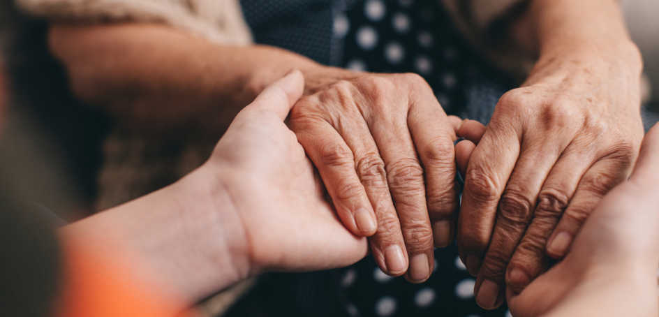 Two pairs of hands embracing one another