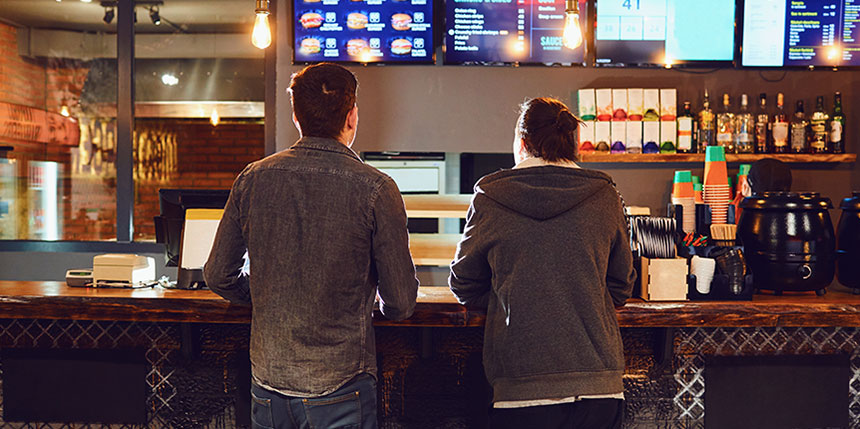 Deux hommes passant une commande à un comptoir de restauration rapide 