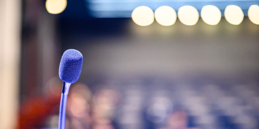 Microphone over the blurred business forum Meeting or Conference Room Concept, Blurred background.