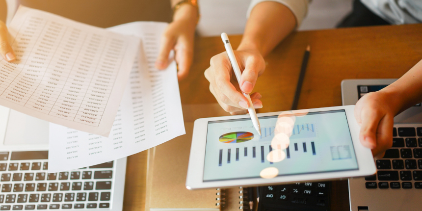 close up group of businessman use stylus pen for explaining dashboard about company's profit monthly on tablet and businesswoman holding report paper for collaborate work at meeting event , business finance concept