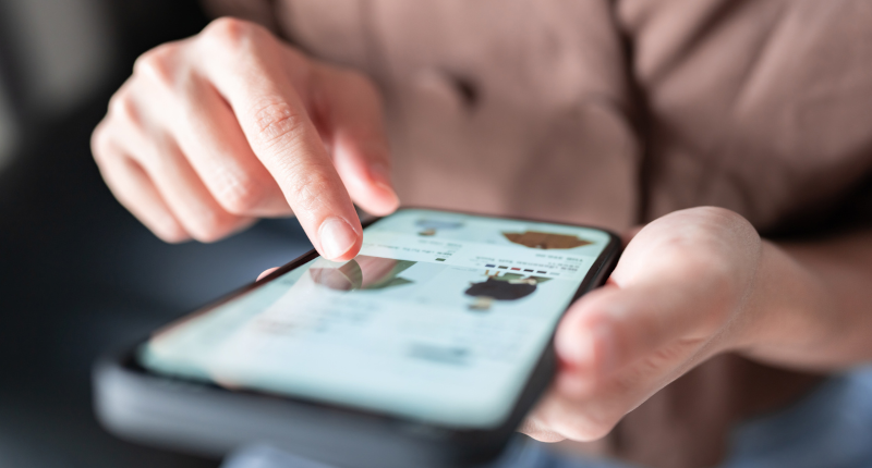 Up close shot of a person's hands scrolling through a search results page on their smartphone.