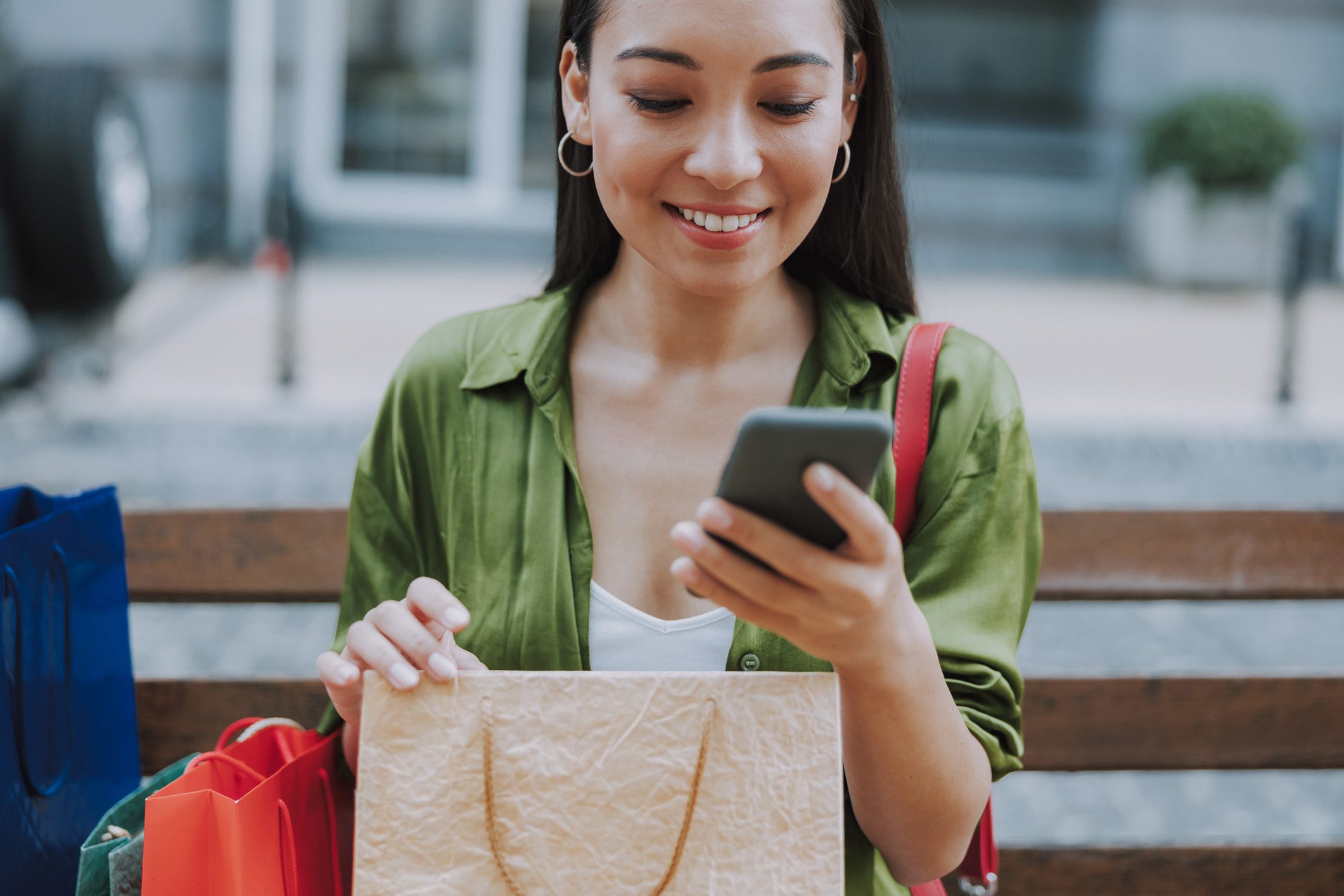 Pretty lady holding smartphone in the city stock photo